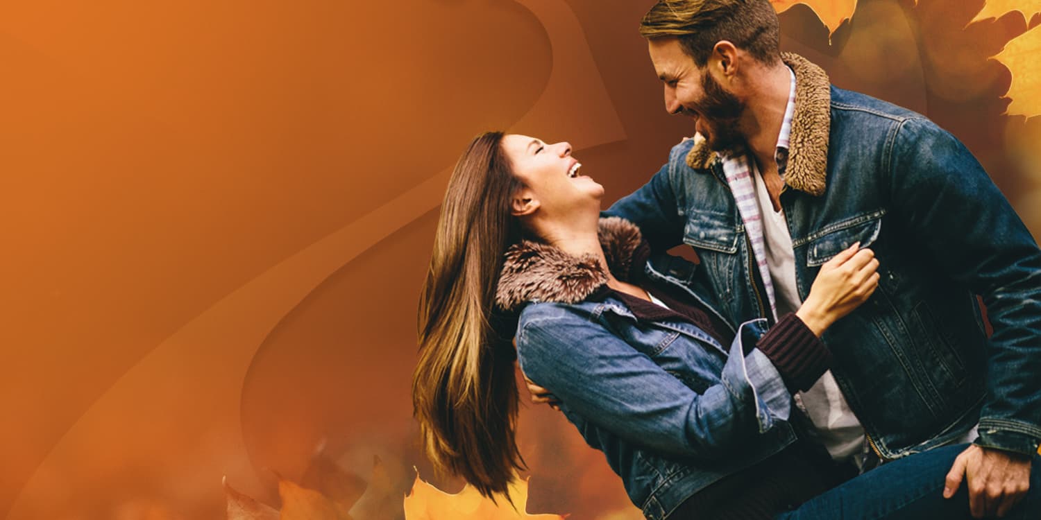 Young couple in love gazing into each other's eyes and dancing in Fall